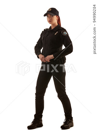 Full length shot of a redheaded female police officer posing for the camera isolated on white background. Full length shot of a redheaded female police officer posing for the camera isolated on white background. 94990284