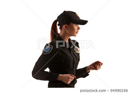 Close-up shot of a redheaded female police officer posing for the camera isolated on white background. Close-up shot of a redheaded female police officer posing for the camera isolated on white background. 94990286