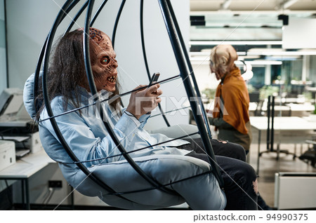 Zombie employee chatting social network in office lounge area Zombie employee chatting social network in office lounge area 94990375
