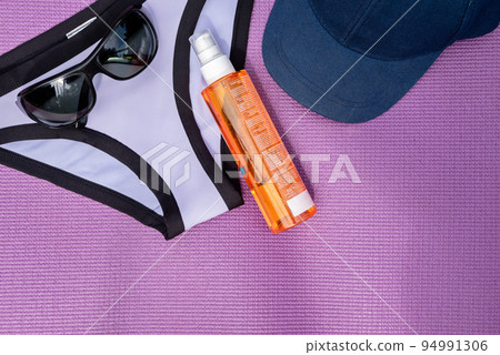 Top view of summer accessories on purple background. Copy-space. Top view of summer accessories on purple background. Copy-space. 94991306