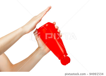 Ketchup bottle in hand. Plastic bottle of ketchup. The hand is holding ketchup. 94991534