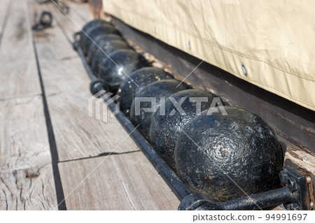 The balls cores for cannon of the 18th century on the desk of old sail battleship The balls cores for cannon of the 18th century on the desk of old sail battleship 94991697