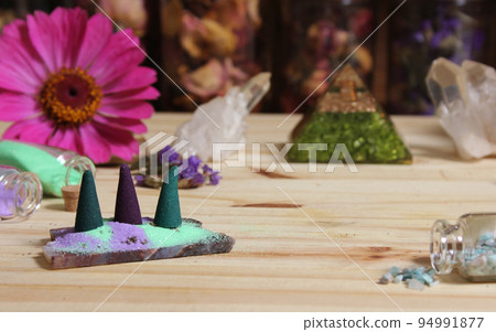 Incense Cones on Stone Slab With Crystals and Flowers 94991877