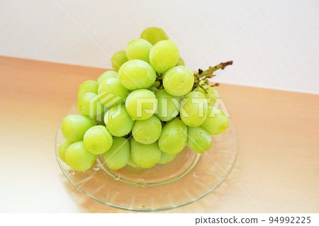 Green grape shine muscat on a wooden desk Green grape shine muscat on a wooden desk 94992225