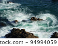 Beautiful traces of waves swirling on the shore 94994059