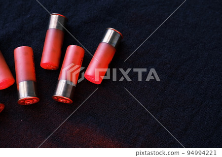 Shotgun shells on a black surface. Ammunition for 12 gauge smoothbore weapons. Hunting ammunition. Dark background. 94994221