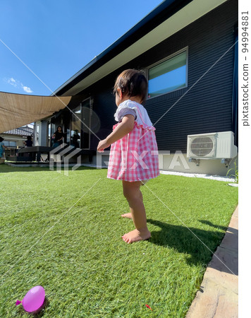 baby girl playing in artificial grass garden 94994881