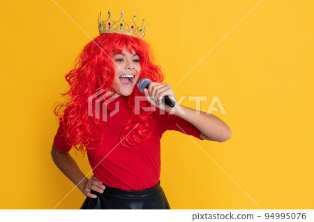 smiling child in crown with microphone on yellow background 94995076