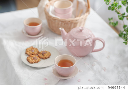 茶杯中的茶和餅乾,櫻花花瓣飄落 茶杯中的茶和餅乾,櫻花花瓣飄落 94995144