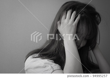 A painful young woman holding her head. monotone 94995257
