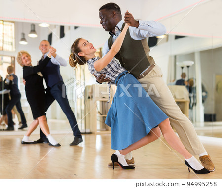 Woman and man dancing waltz in studio 94995258