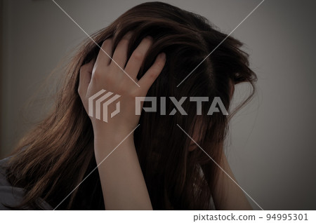 痛苦的年輕女人抱著她的頭 痛苦的年輕女人抱著她的頭 94995301