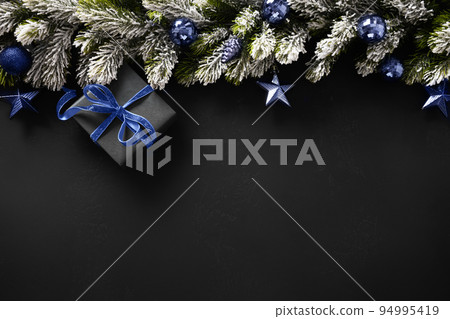 Christmas winter banner with fir branches, blue navy balls on black background. Xmas greeting card. Christmas winter banner with fir branches, blue navy balls on black background. Xmas greeting card. 94995419