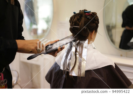 Male hairdresser coloring woman's hair Male hairdresser coloring woman's hair 94995422