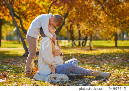 little son hugs his pregnant mom on the nature 94997345