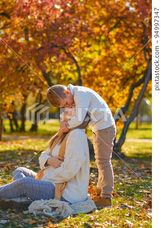 little son hugs his pregnant mom on the nature little son hugs his pregnant mom on the nature 94997347