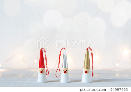 Three Santa Clauses on white background with garland lights 94997463
