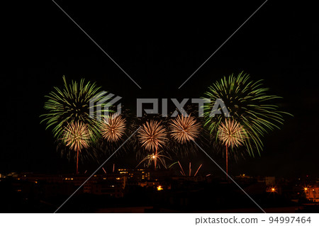 Green and yellow fireworks in a night sky Green and yellow fireworks in a night sky 94997464