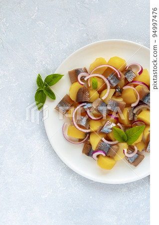 Portion of smoked salmon, potato and red onion salad 94997476