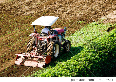 耕田的農業機械紅色拖拉機 耕田的農業機械紅色拖拉機 94998683