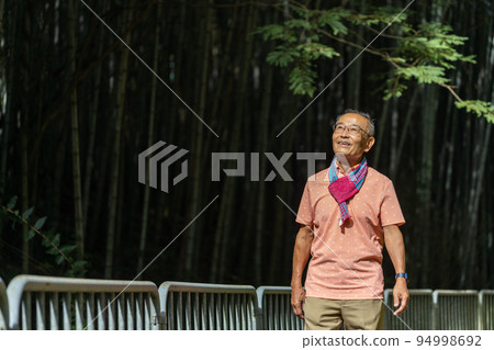 Cheerful and lively senior man doing his hobby walking with a smile Cheerful and lively senior man doing his hobby walking with a smile 94998692