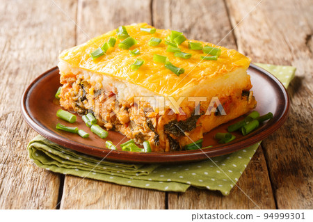 Portion of shepherd's pie of mashed potatoes with minced meat and vegetables on top with cheese close-up on a plate. horizontal Portion of shepherd's pie of mashed potatoes with minced meat and vegetables on top with cheese close-up on a plate. horizontal 94999301