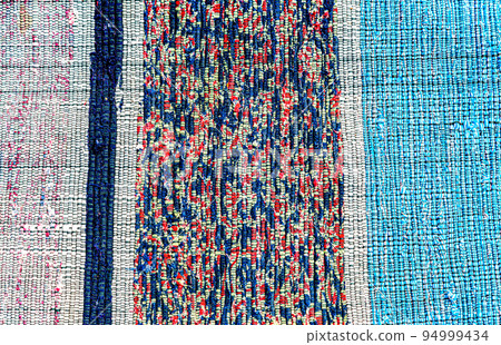 Vintage homespun doormat made from strips of cloth as background Vintage homespun doormat made from strips of cloth as background 94999434