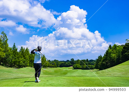 A golfer playing under clear skies [ image of golf ] 94999503
