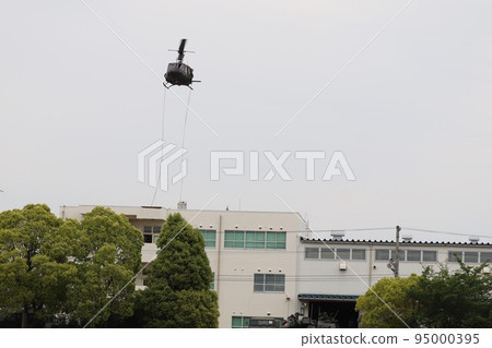 Ground Self-Defense Force UH-1 helicopter dropping personnel onto the roof of a building 95000395