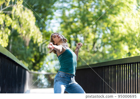 Athletic pose of an attractive 22 yo blonde girl on a pedestrian bridge 95000695