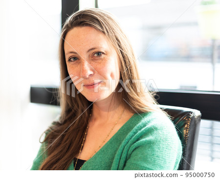 Attractive thirty year old white woman sitting on a chair 95000750