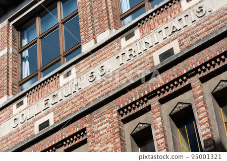 Leuven, Flemish Brabant - Belgium - 06 20 2021 The collegium trinitatis inscription, meaning the Trinitiy collega, brick stone facade of a school 95001321