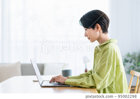Middle woman teleworking in the living room Middle woman teleworking in the living room 95002298