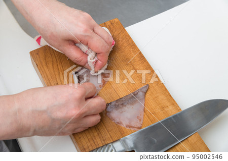 [A middle-aged housewife prepares a squid and peels the skin of the enpera with a cloth] 95002546