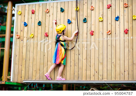 Child in adventure park. Kids climbing rope trail. 95004787