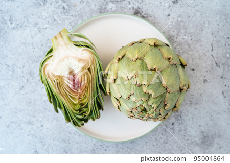 Top view Sliced artichoke on plate on table. Healthy food vegetables. 95004864