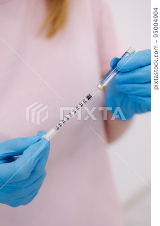 Cosmetoloist injectionist hold syringe in hands. Close-up 95004904