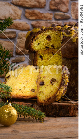 Traditional Italian Christmas Cake Panettone with green bow with cut piece of cake on rustic wooden background Traditional Italian Christmas Cake Panettone with green bow with cut piece of cake on rustic wooden background 95004961