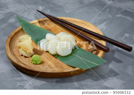 Fresh octopus sashimi on bamboo leaf on wooden bard 95006332