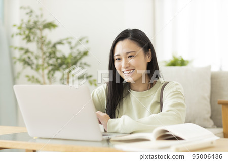Young female college student high school student studying while looking at a computer 95006486