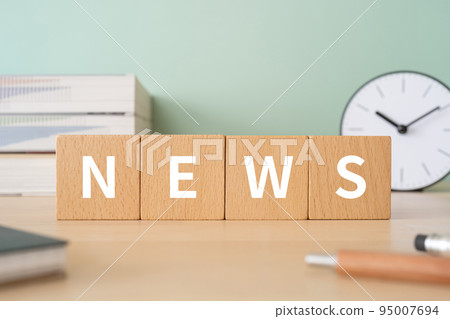 A desk with a block written NEWS 95007694