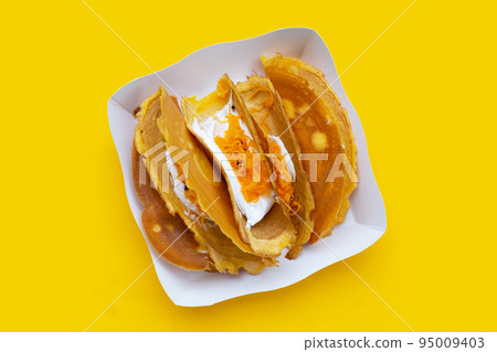 Thai crispy pancakes on yellow background. Thai crispy pancakes on yellow background. 95009403