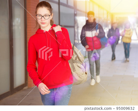 Teen girl in glasses walking to college 95009632