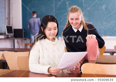 Happy asian female student reading notification with girl friend Happy asian female student reading notification with girl friend 95009639