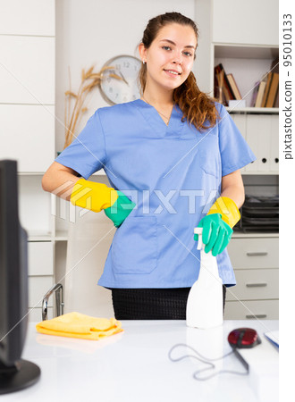 Young friendly cleaning woman in work uniform Young friendly cleaning woman in work uniform 95010133
