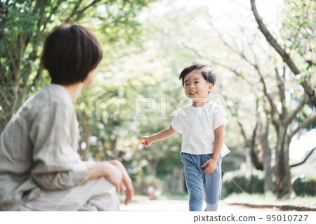 Mom watching a child running on the sidewalk 95010727
