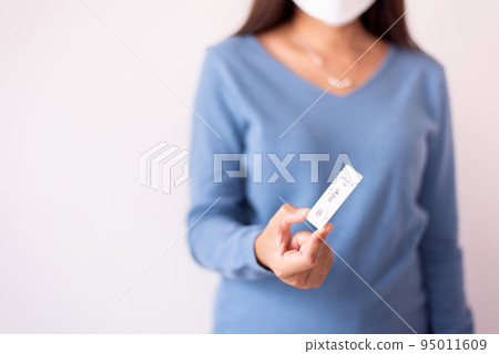 Sick woman hands holding positive test result for coronavirus or covid 19 on white background Sick woman hands holding positive test result for coronavirus or covid 19 on white background 95011609