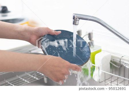 Hands of a woman washing dishes Hands of a woman washing dishes 95012691