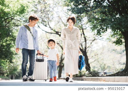 Family trip/child pulling a suitcase 95015017