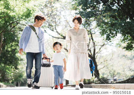 Family trip/child pulling a suitcase 95015018